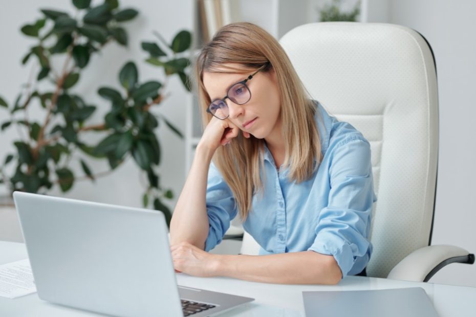 Sad woman starting at the computer because of workplace bullying