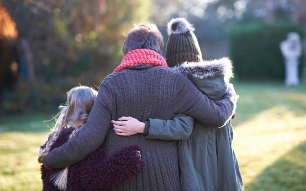 Grieving family in garden, knowing about death benefit claims