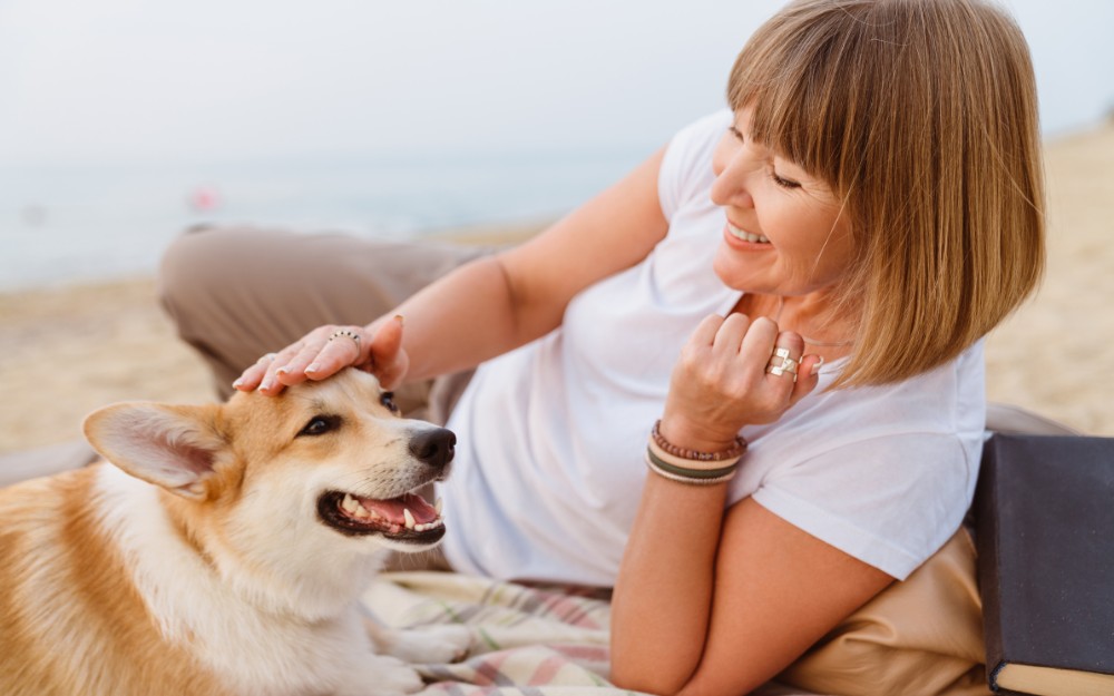 Woman who has done estate planning for pets with her dog at the beach
