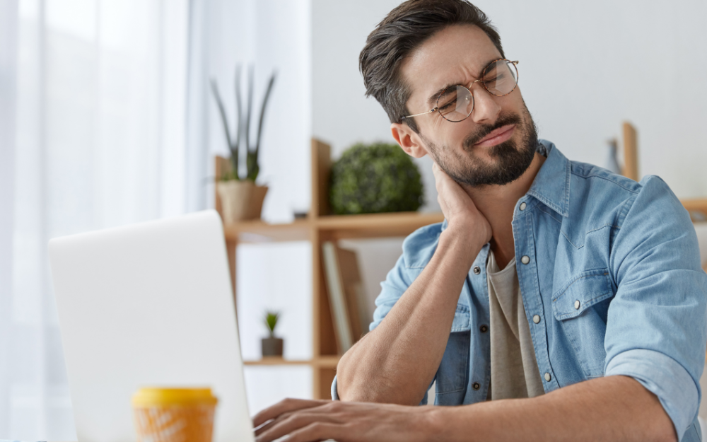 Male independent contractor with neck pain while working.
